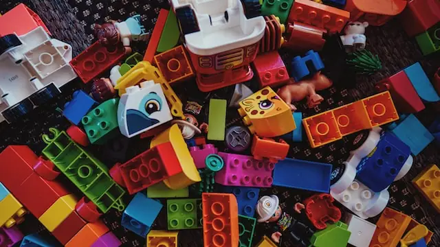 a pile of colorful construction blocks sitting on top of a carpet